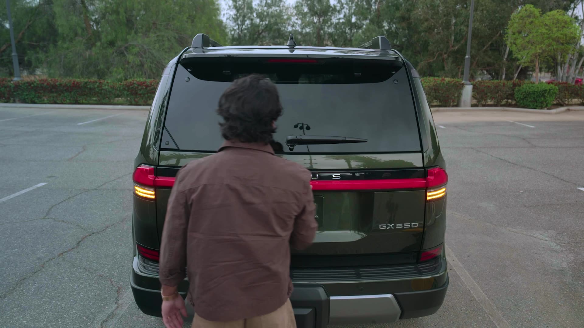 Standing at the open trunk of the GX 550
